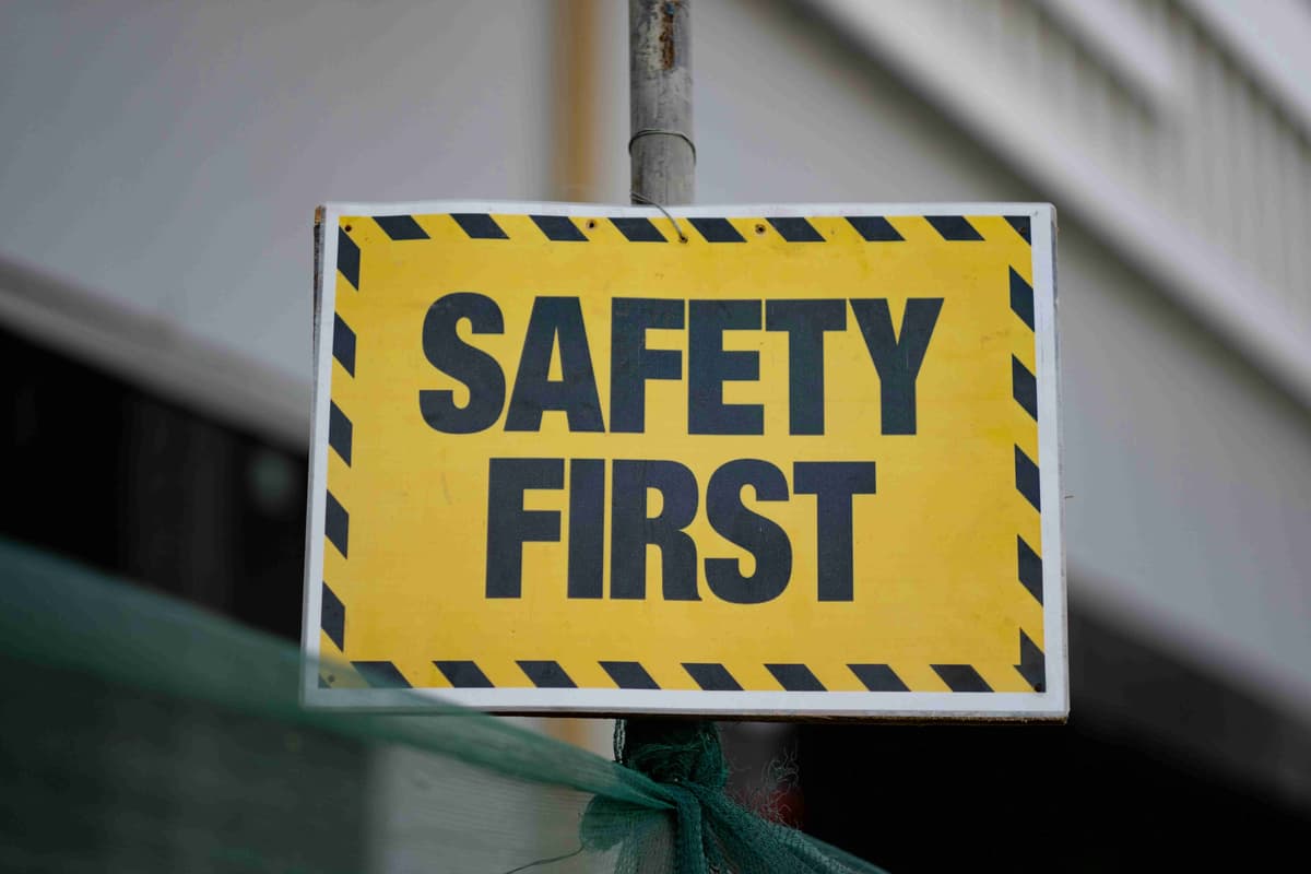 a-yellow-and-black-safety-first-sign-on-a-pole