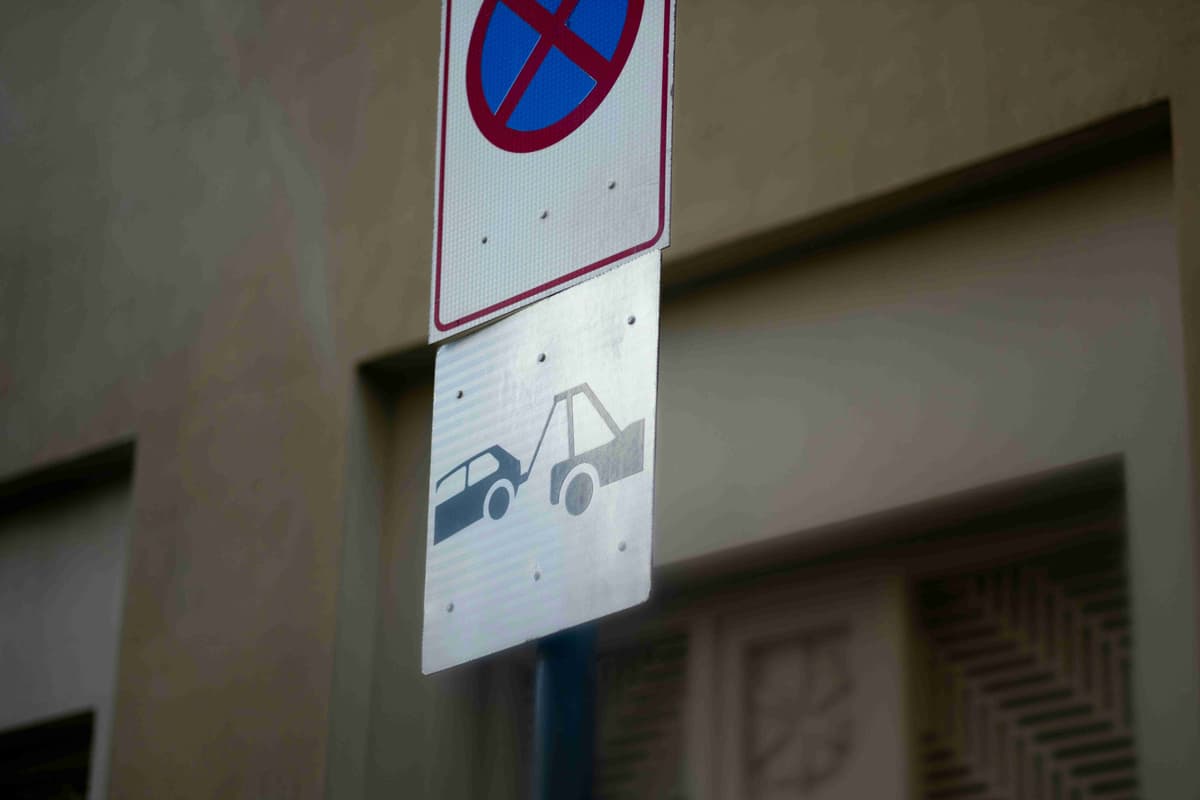 a-no-parking-sign-on-a-pole-next-to-a-building