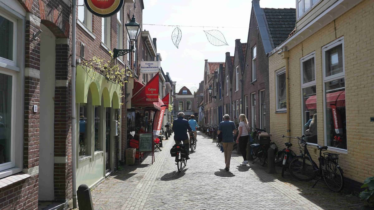 "Narrow Street with Cyclists and Pedestrians in a Quaint European Town"