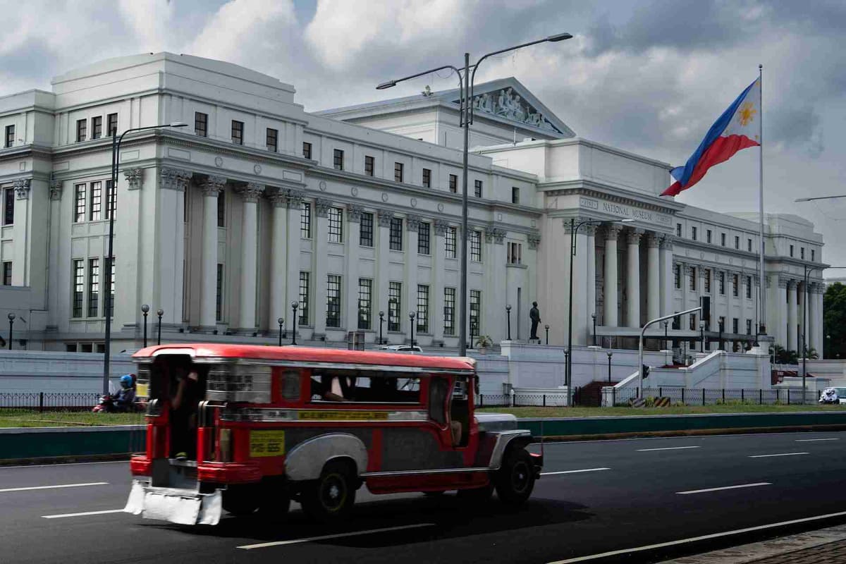 Národné múzeum Filipín s prechádzajúcim džípom.