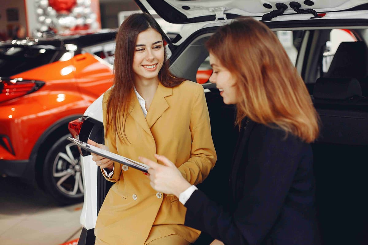 friendly-car-dealer-showing-the-contract-to-a-customer