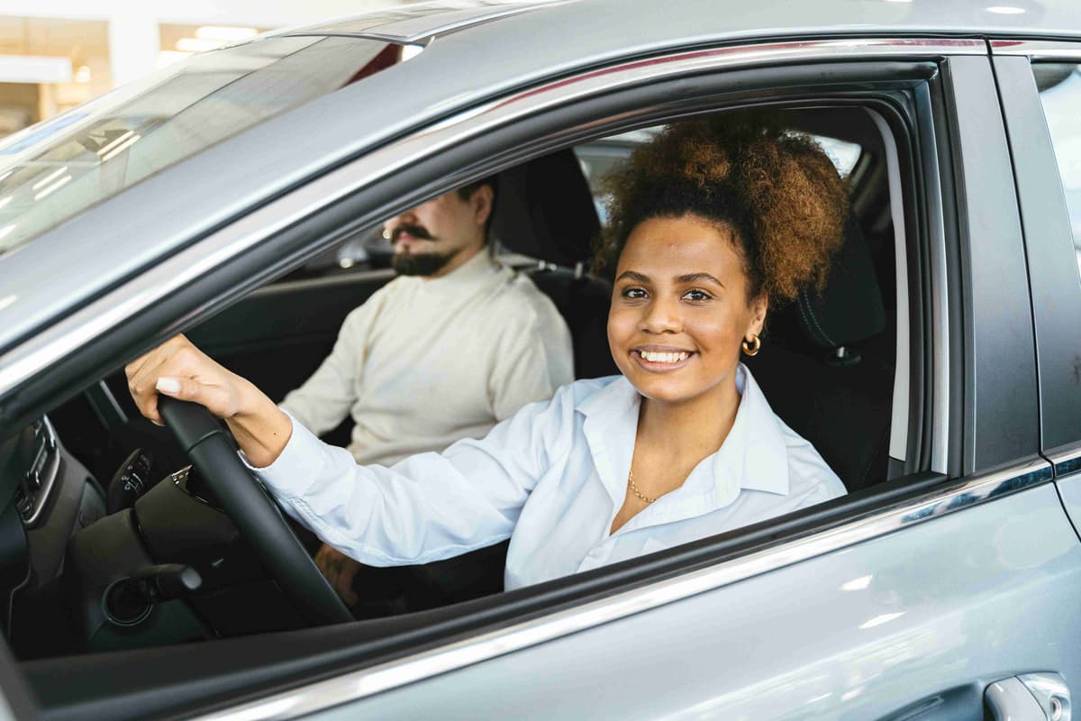smiling woman sitting inside the car