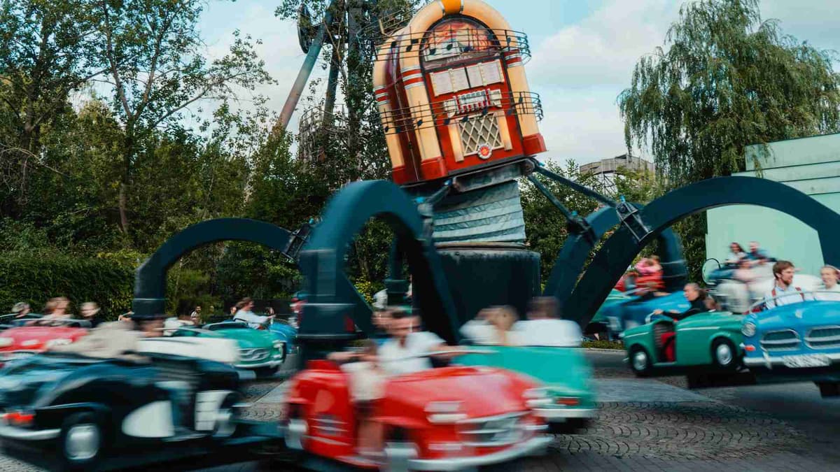 Blur of motion as cars spin around a track at Liseberg Park.