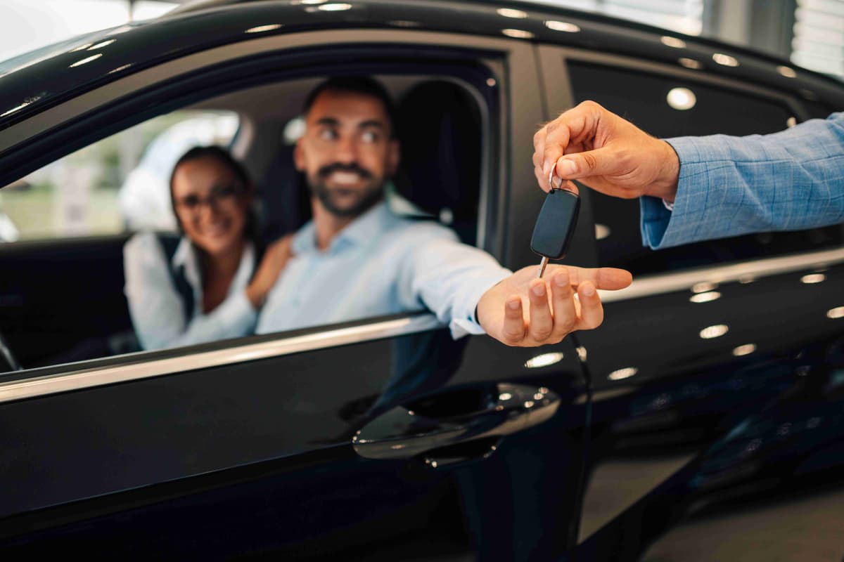 Salesperson in a dealership handing car keys