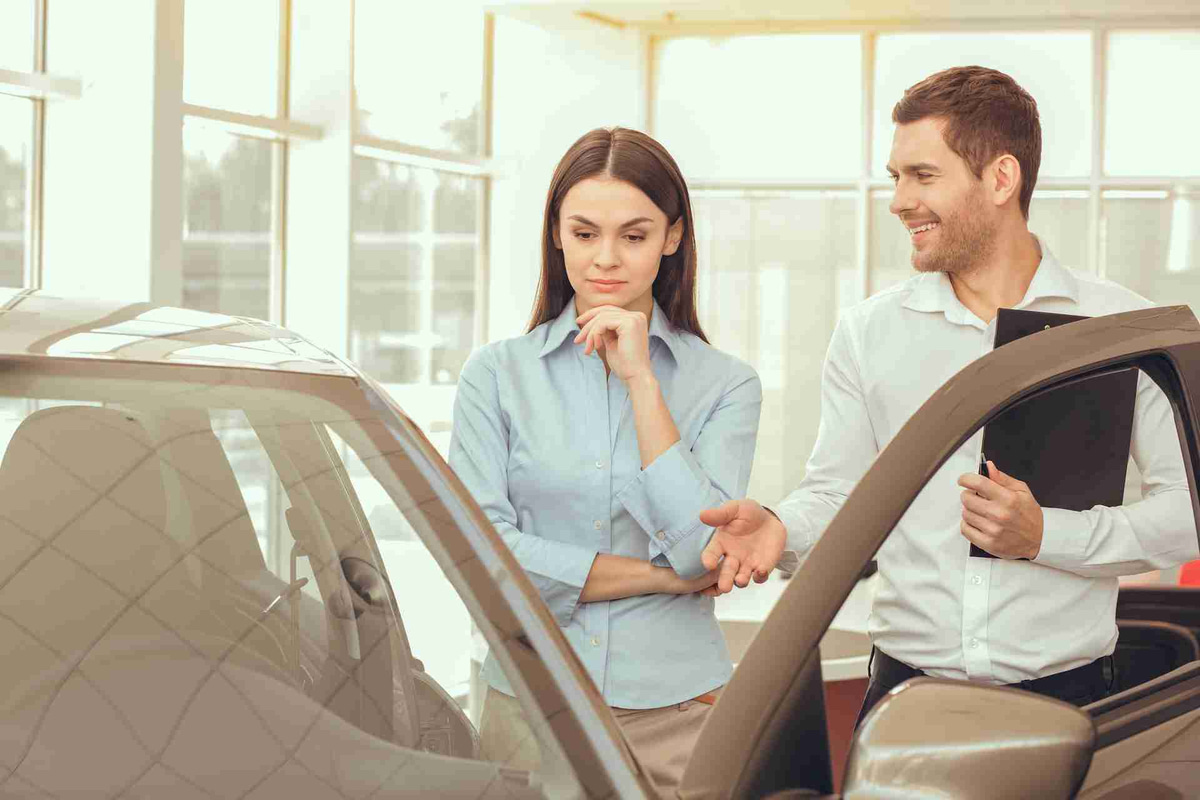 Car Salesman Showing Vehicle Features to Potential Buyer