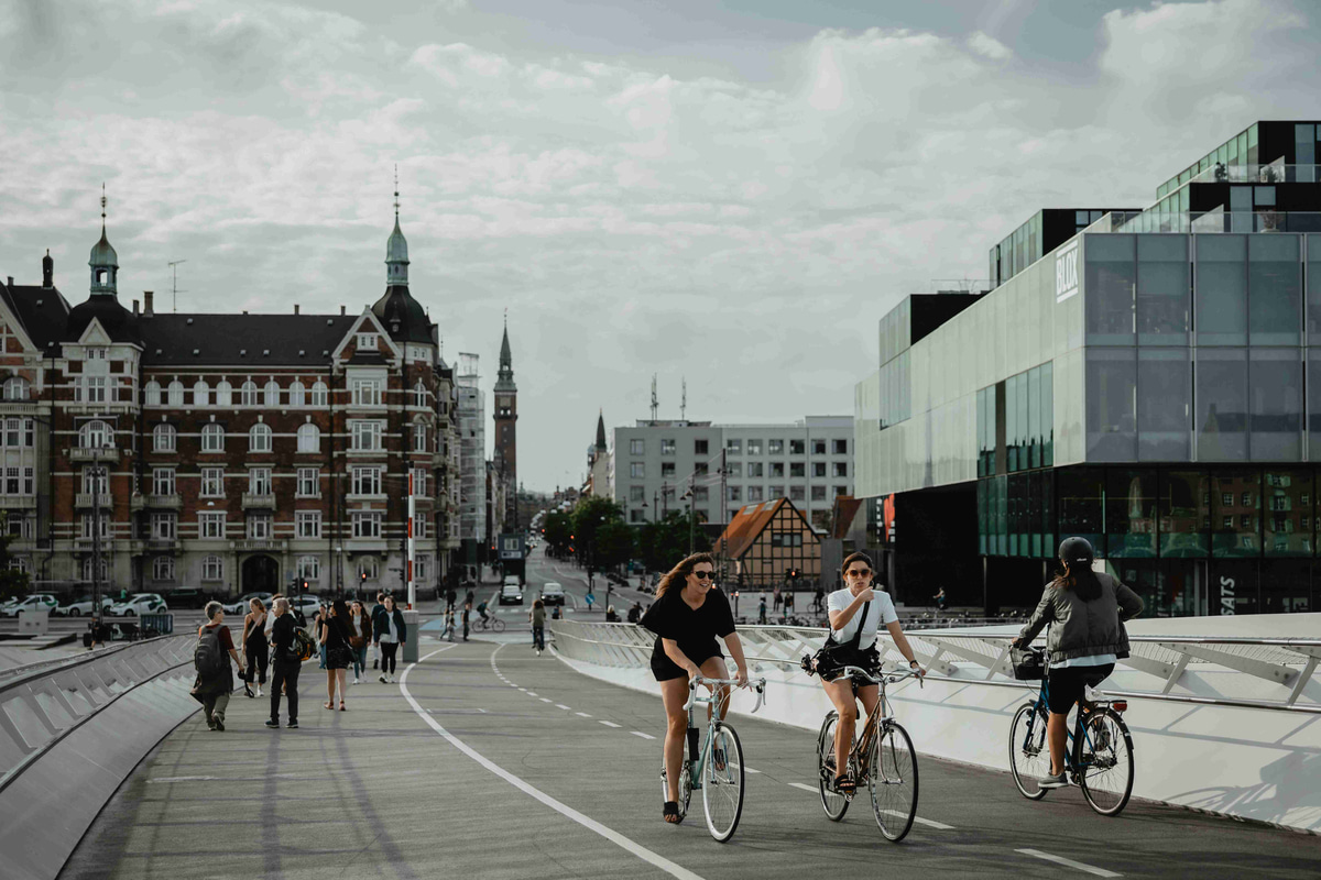 Cycling_Across_the_Modern_Bridge_with_Historic_City_Backdrop