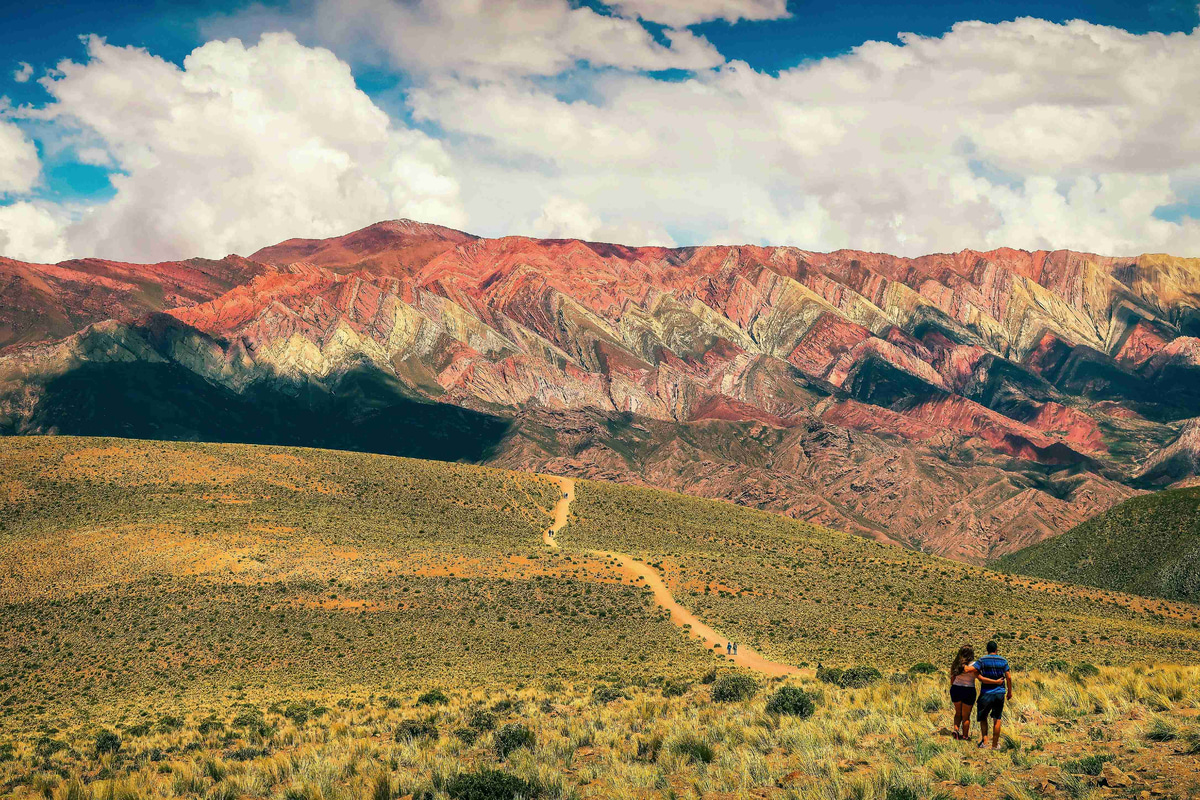 Hikers_Approaching_Multicolored_Mountain_Range