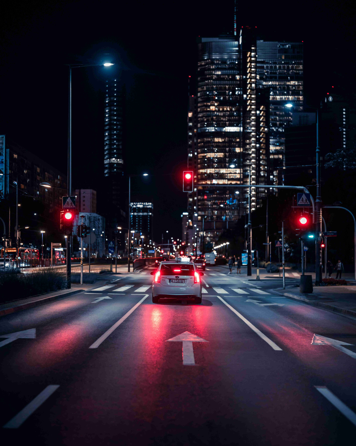 Nighttime_City_Street_with_Red_Traffic_Lights_and_Skyscrapers