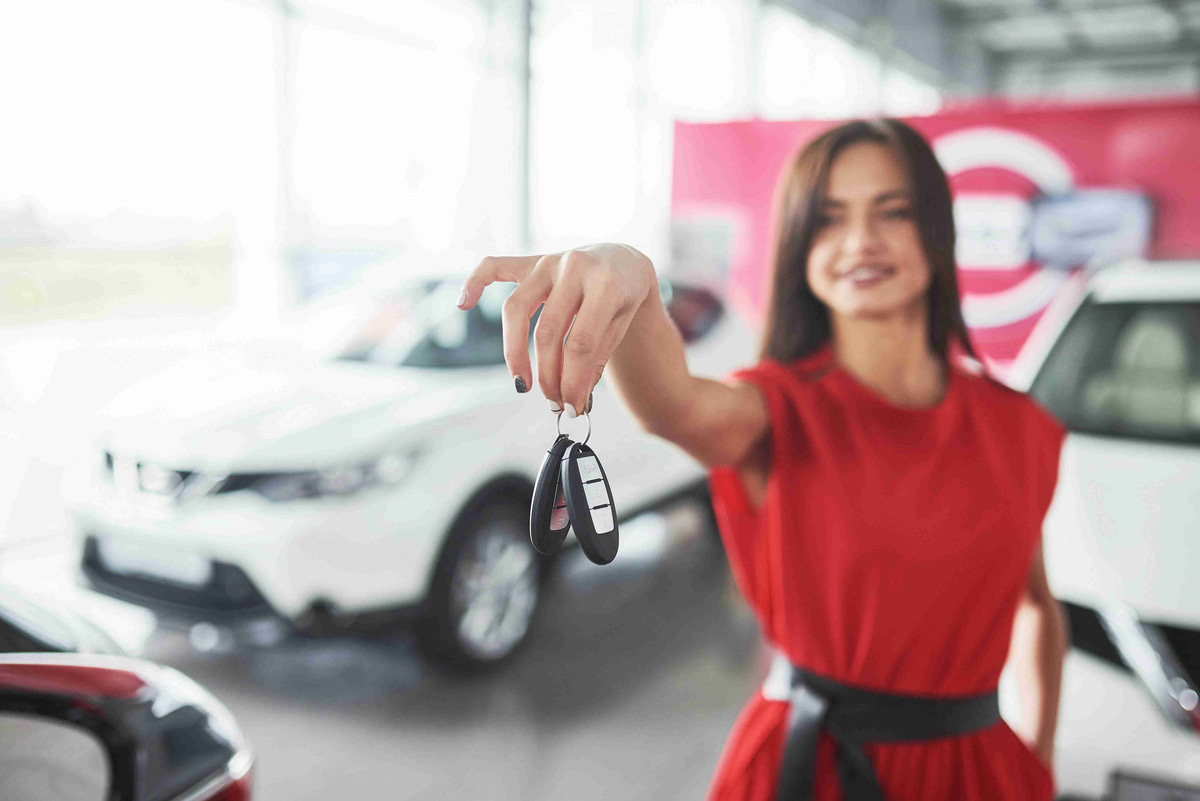 car_saleswoman_handing_keys_showroom